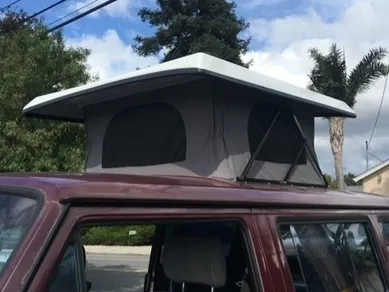 A car with a roof tent on top of it.