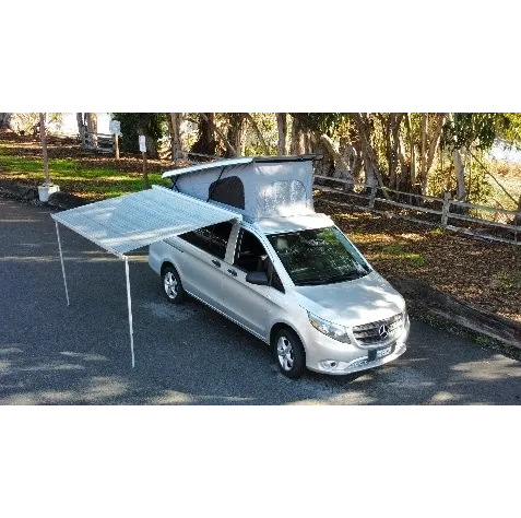 A silver van with a tent on the back.