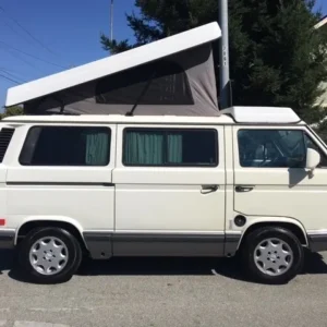 A white van with an open roof on the street.