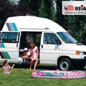 A van with people sitting in it and a child laying on the ground.