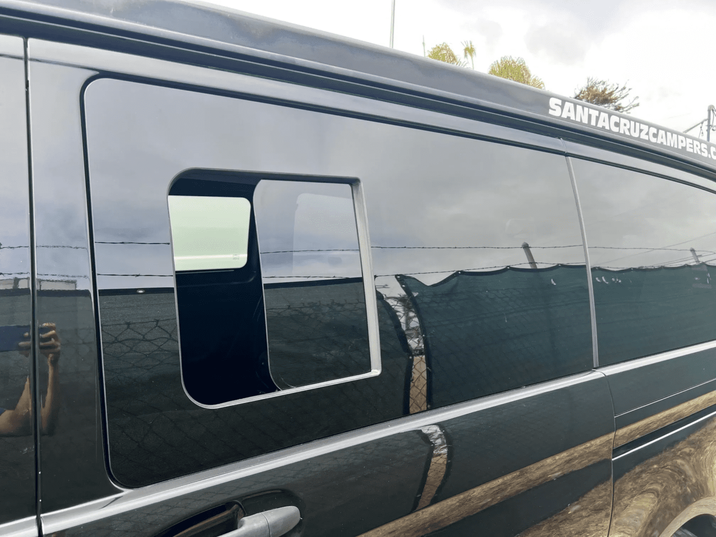 A black van with the door open and windows closed.